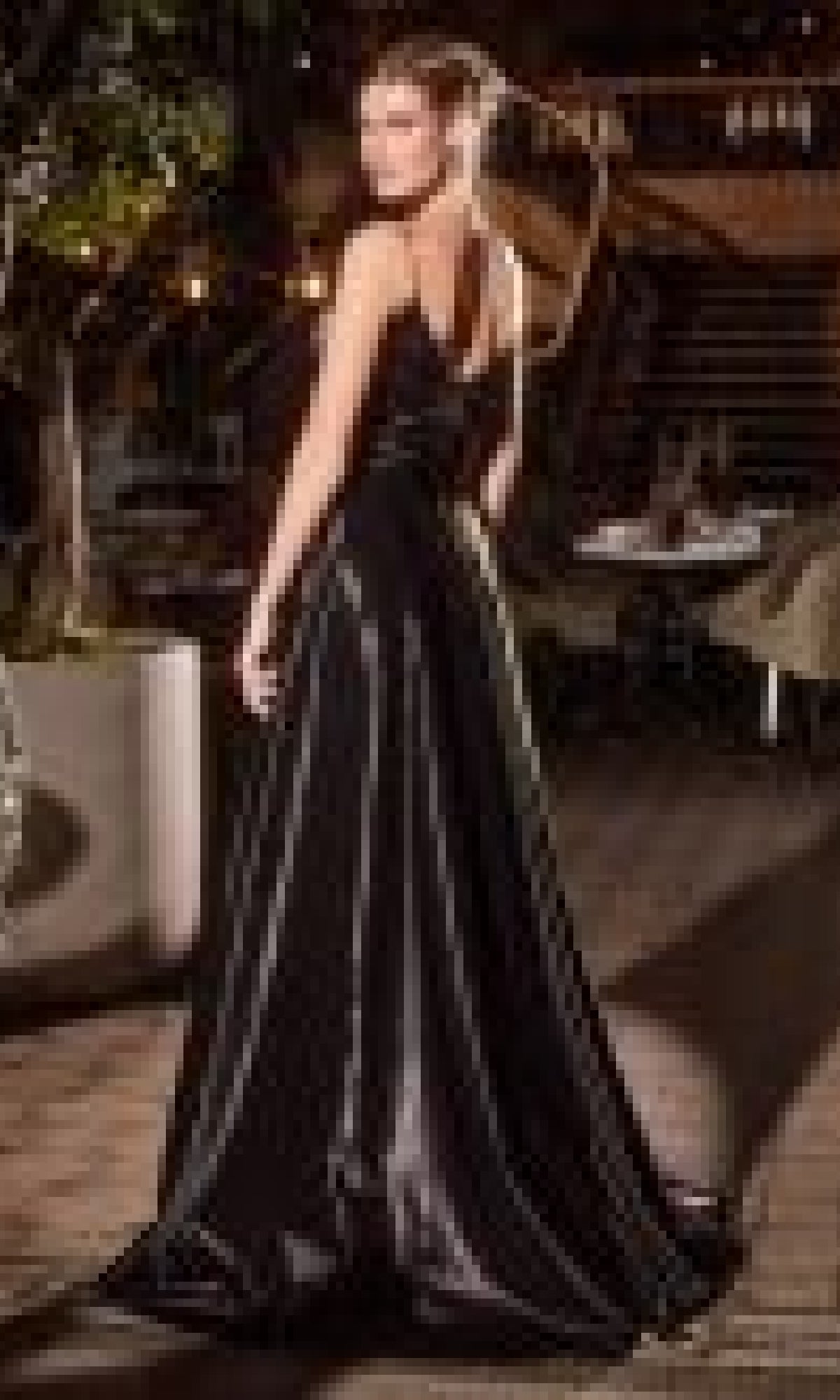 A woman in the Jacket Long Black Formal Dress: Ladivine J882 stands outdoors, facing away and glancing over her shoulder.